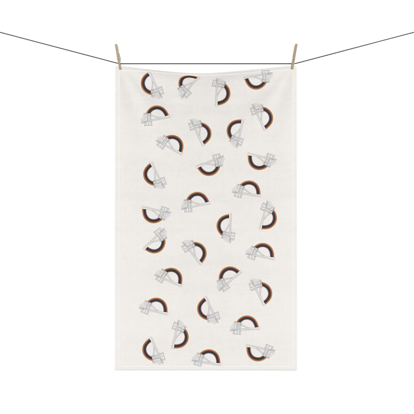 FYRNE tea towel with a repeating pattern of Brooklyn Bridge line drawings and curved rainbow arches, shown hanging from a clothesline