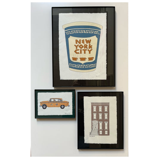 Set of three hand illustrated New York prints framed in black: yellow cab, coffee cup and brownstone.