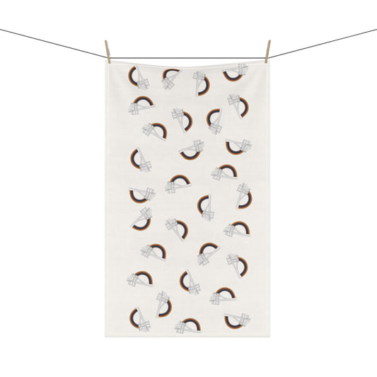FYRNE tea towel with a repeating pattern of Brooklyn Bridge line drawings and curved rainbow arches, shown hanging from a clothesline